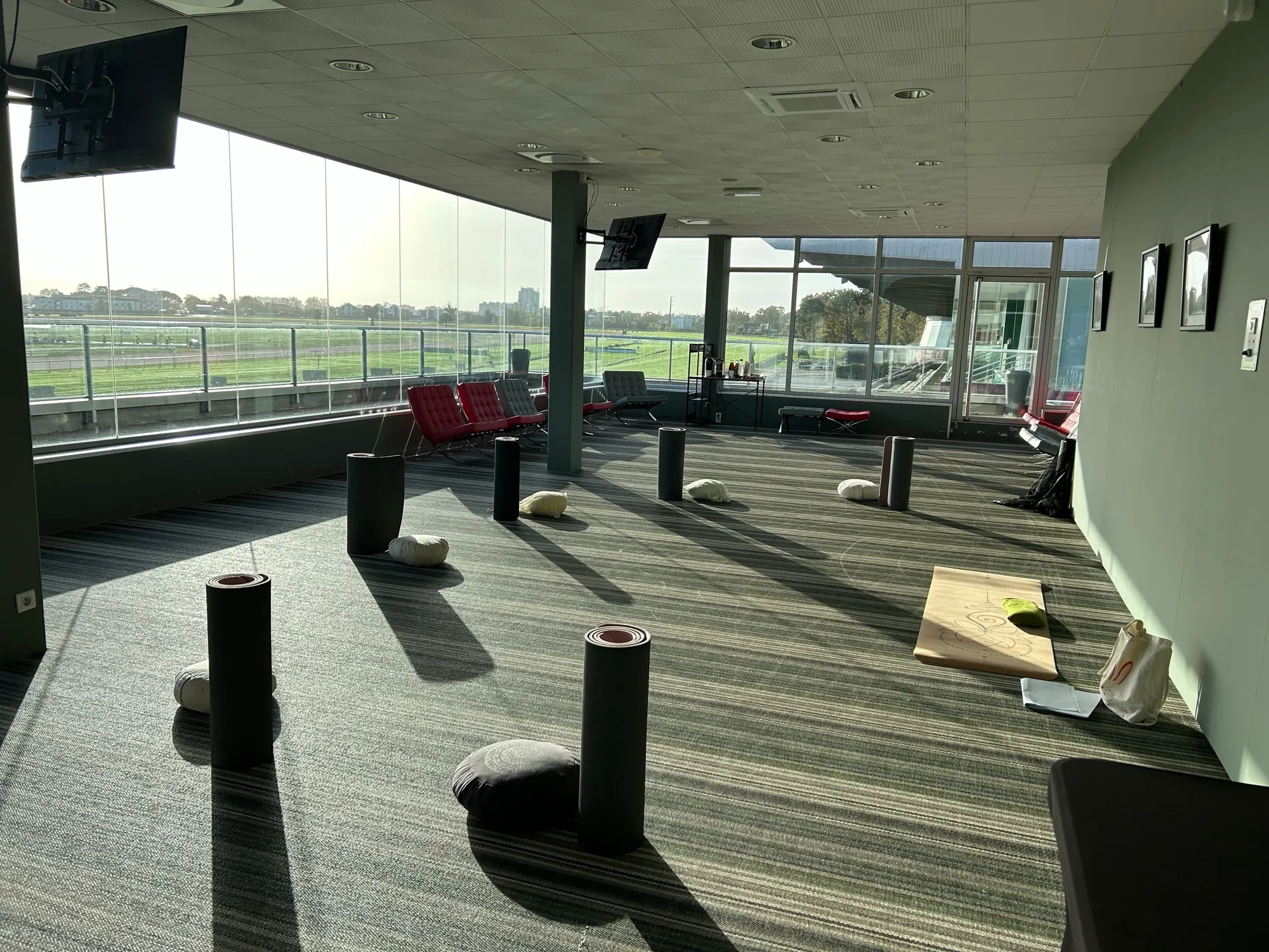 La salle de pratique MBSR à l'hippodrome du Bouscat, coussins et tapis disposés face à la lumière de fin de journée